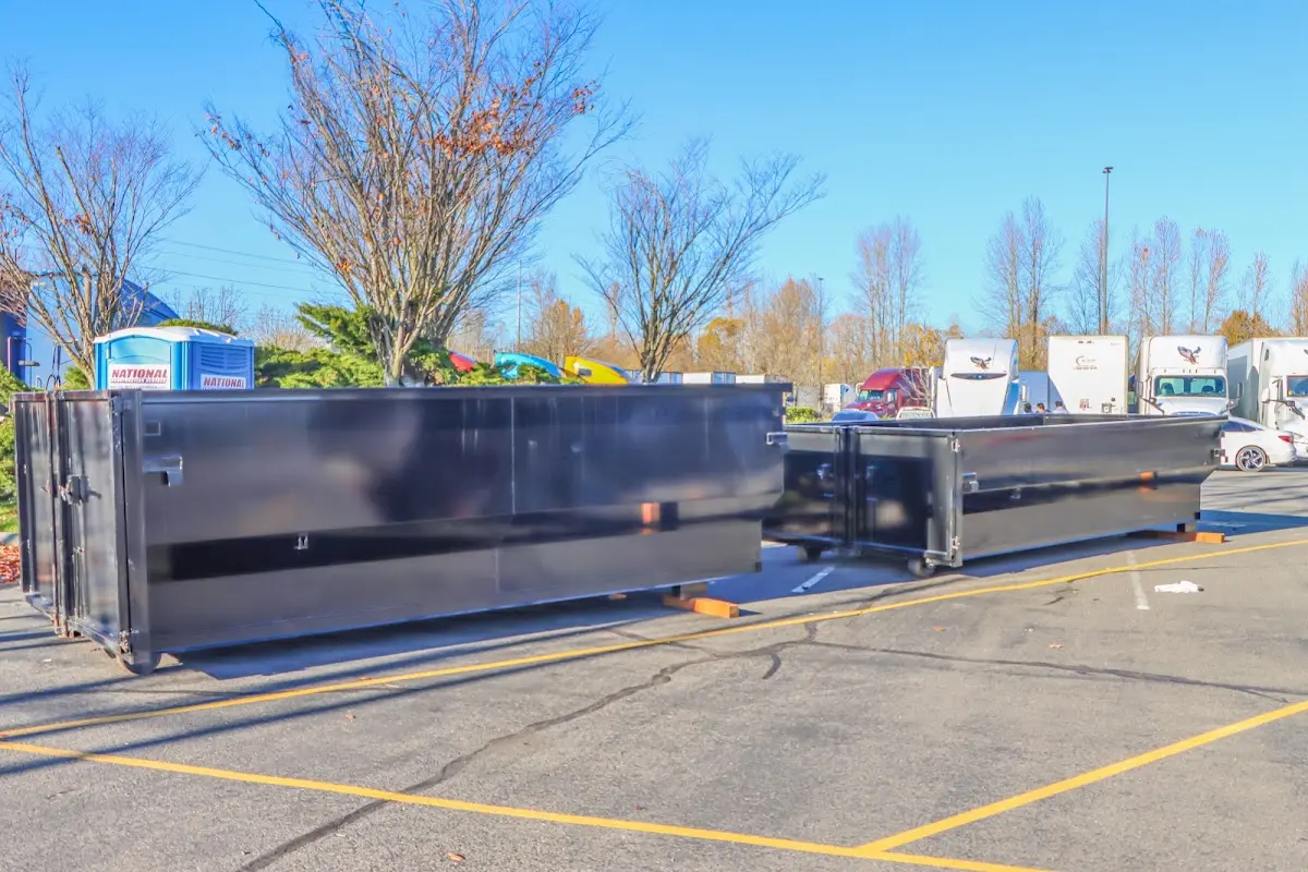 Professional dumpster rental service with roll-off container on residential driveway in Fort Mohave